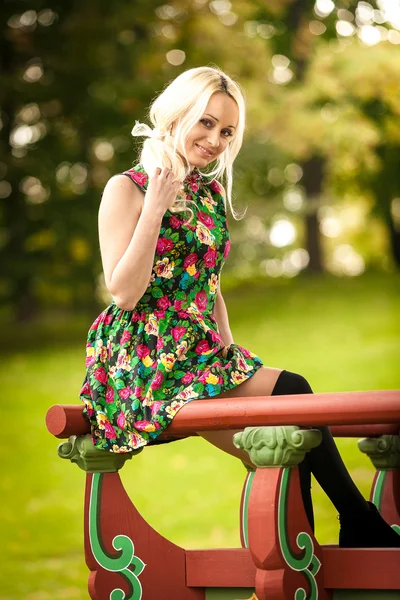 Mulher loira sentada no gazebo chinês no parque — Fotografia de Stock