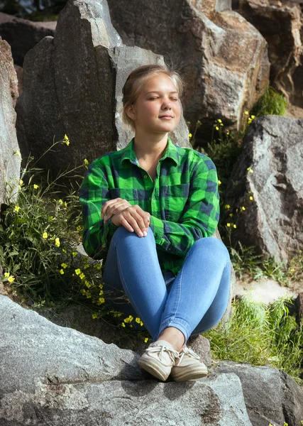 Hipster girl relaxing on high cliff at sunny day — Stock Photo, Image