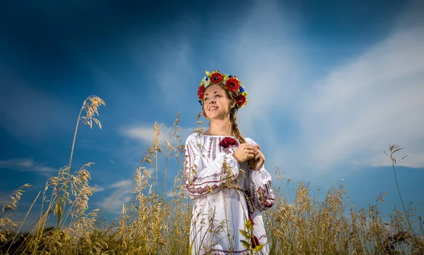 Mooie Oekraïense meisje met vlecht poseren op veld — Stockfoto