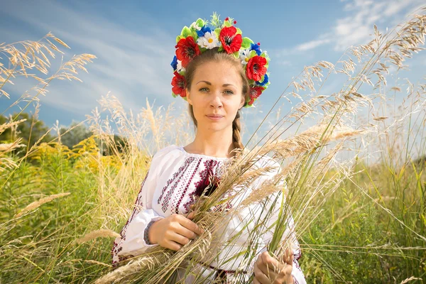 Portrait of ukrainian woman in wreath at wheat field — Stock Photo, Image