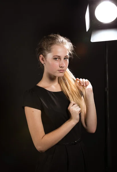 Sexy blonde woman against black background with studio flash — Stock Photo, Image