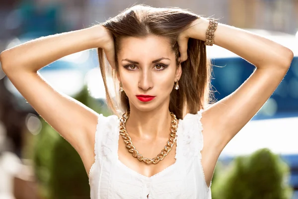 Ritratto di donna bruna sexy che solleva i capelli lunghi sulla strada — Foto Stock