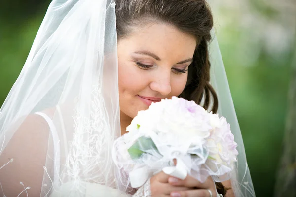 Портрет милой брюнетки невесты, пахнущей свадебным букетом — стоковое фото