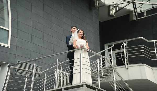 Just married couple standing on stairs at modern building — Stock Photo, Image