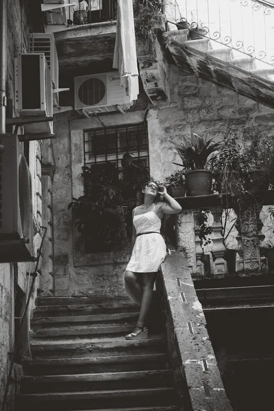 Monochrome photo of beautiful woman in standing on old stone sta — Stock Photo, Image