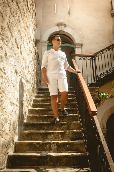 Hombre caminando por la vieja escalera de piedra en un día soleado — Foto de Stock