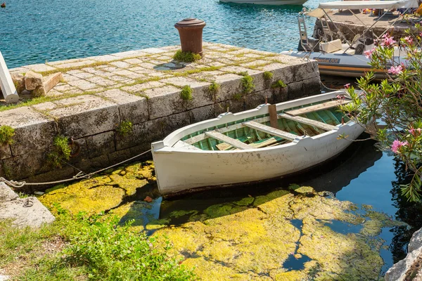 Barco a remos de madeira amarração no cais no dia ensolarado — Fotografia de Stock