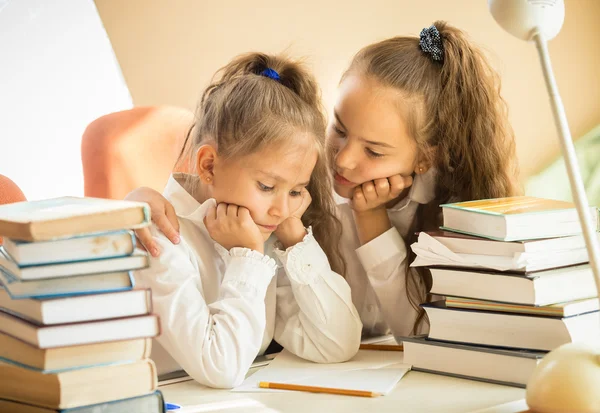 Older sister soothing younger one while doing homework — Stock Photo, Image