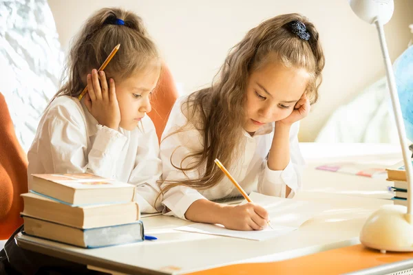 Oudere zus huiswerk uit te leggen aan jongere — Stockfoto