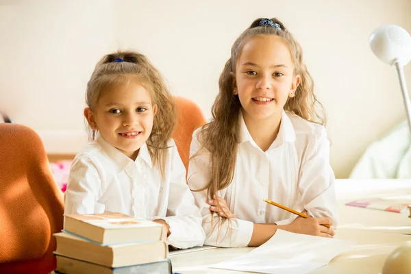 Två klasskamrater sitter vid skrivbord och ler — Stockfoto