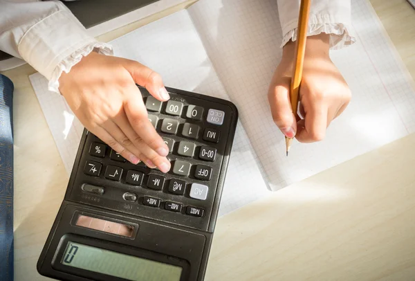 Chica resolver la tarea de matemáticas en la calculadora —  Fotos de Stock