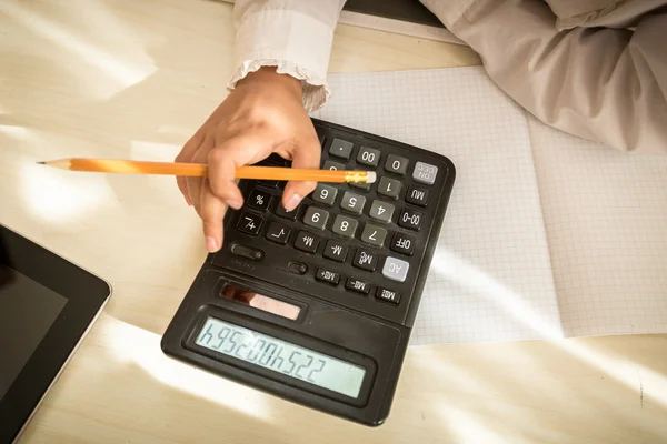 Meisje houdt van potlood en met behulp van calculator — Stockfoto