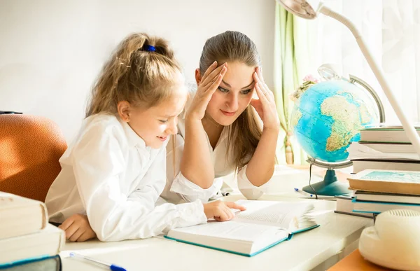 Matka mylić patrząc na córki skomplikowane zadanie domowe — Zdjęcie stockowe
