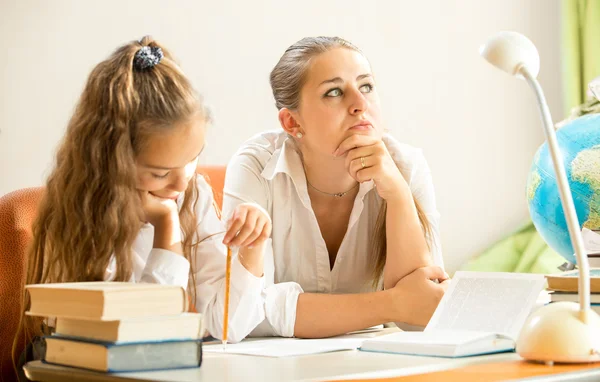 Mutter träumt, während Tochter Hausaufgaben macht — Stockfoto