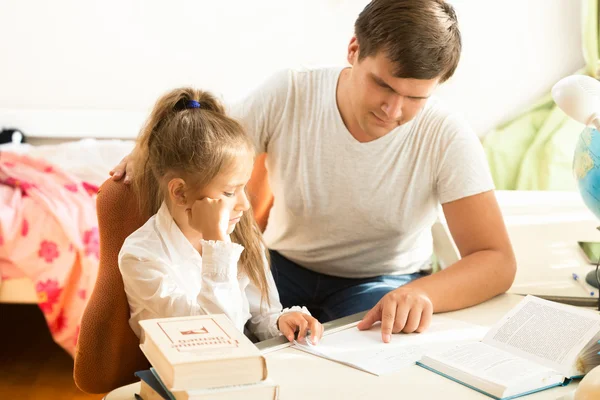 Man förklarar dotter hur man gör läxor — Stockfoto