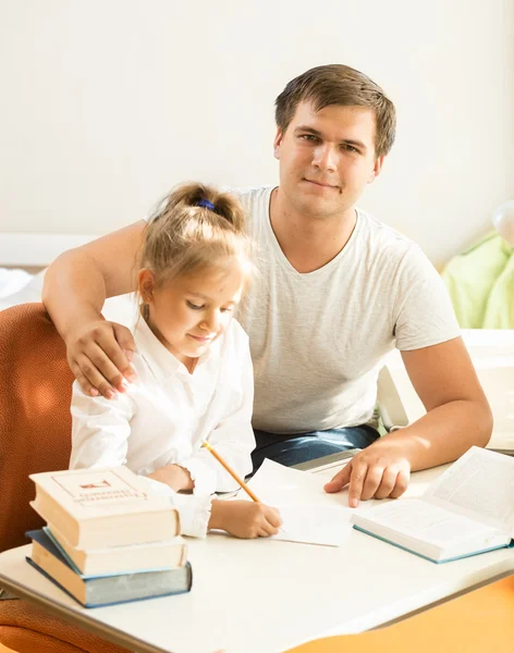 Handsome man helping daughter with homework — Stock Photo, Image