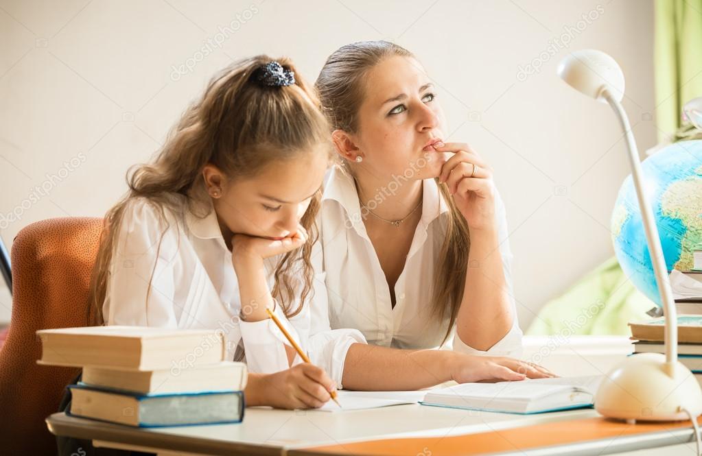 Mother trying to solve complicated exercise with little daughter