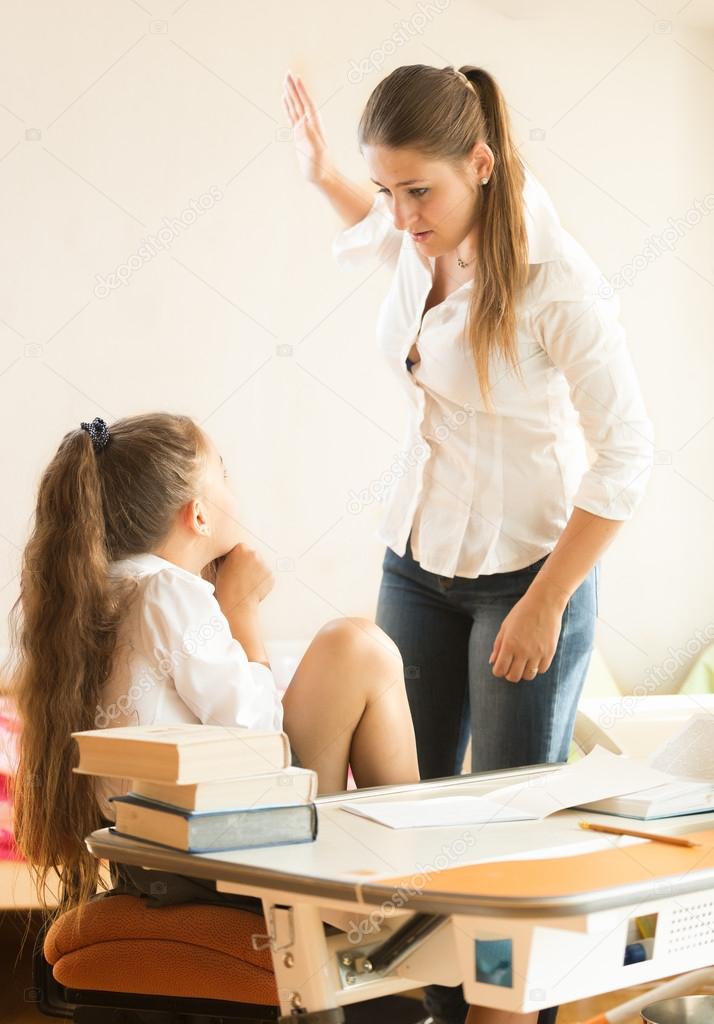 angry mother hitting intimidated daughter