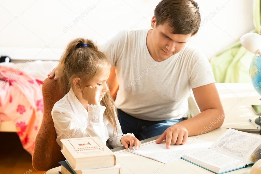 man explaining daughter how to do homework 