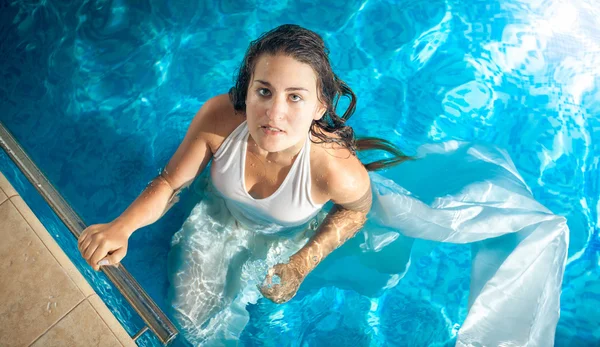 Mulher sexy no vestido branco nadando na piscina no dia ensolarado — Fotografia de Stock