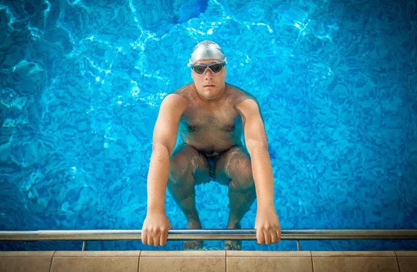 Atleta masculino sosteniendo en el borde de la piscina y preparándose para s —  Fotos de Stock