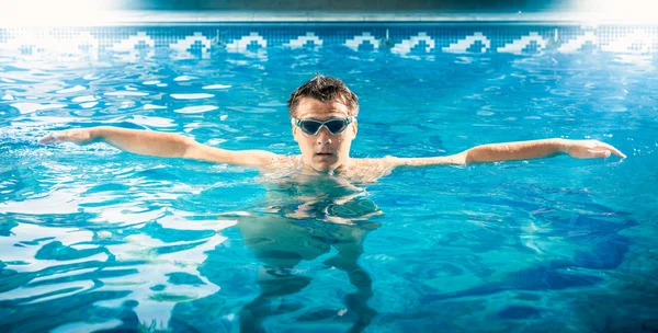 Joven nadador masculino tomando un respiro y relajarse en la piscina —  Fotos de Stock