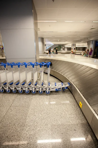 Foto van rij van bagagewagens en bagage claim lijn — Stockfoto