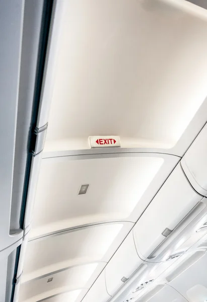 Ausstiegsschild an der Decke eines Flugzeugs mit Licht — Stockfoto
