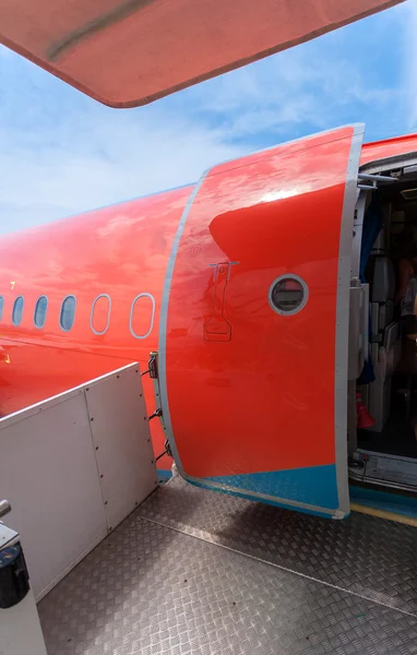 Puerta abierta de gran avión civil pintado de rojo — Foto de Stock