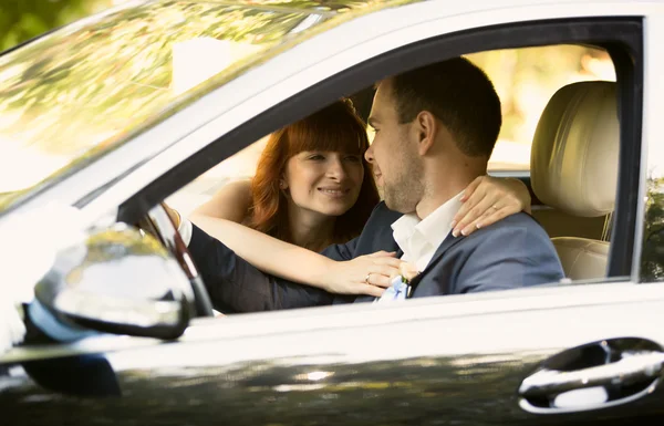 Noiva feliz e noivo montando um carro — Fotografia de Stock