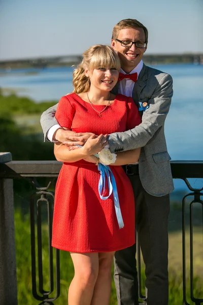 Portret van lachende man vriendin knuffelen op de rivieroever — Stockfoto