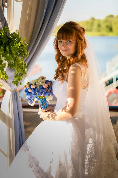 Hermosa pelirroja novia celebración ramo en verano terraza — Foto de Stock