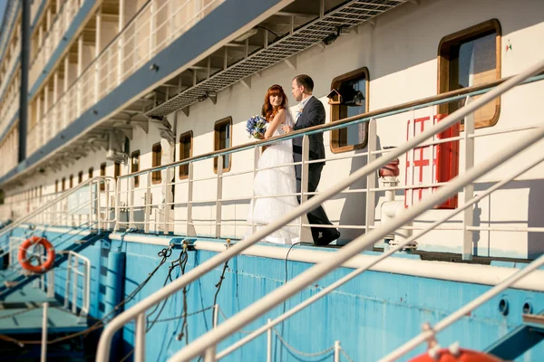 Sposa e sposo in piedi sul ponte della nave da crociera al tramonto — Foto Stock