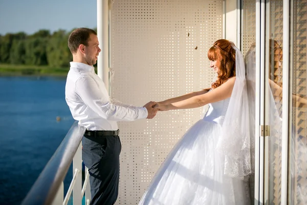 Newly married couple holding hands on  cruise liner — Stock Photo, Image