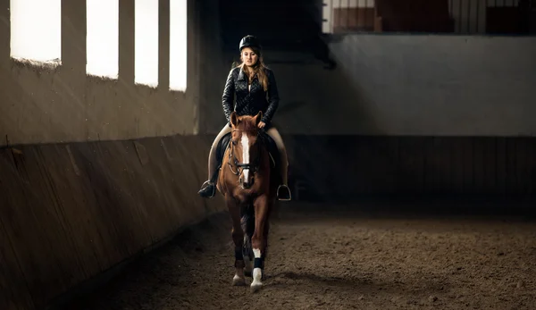 Photo de femme équitation cheval sur le manège dans le hall d'équitation — Photo