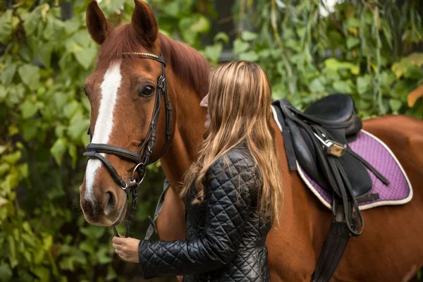Photo de belle femme tenant le cheval par la rêne — Photo