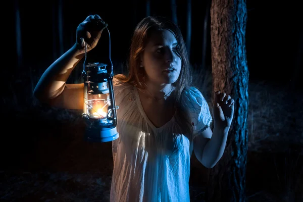 Portrait de femme effrayée perdu dans la forêt illuminant le chemin avec — Photo