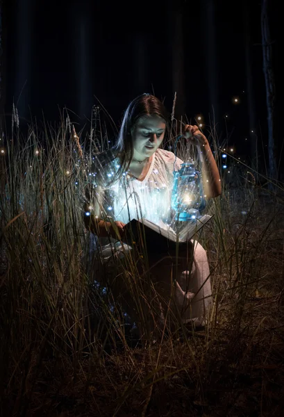 Mujer sonriente en camisón sentado en el campo por la noche y leyendo —  Fotos de Stock