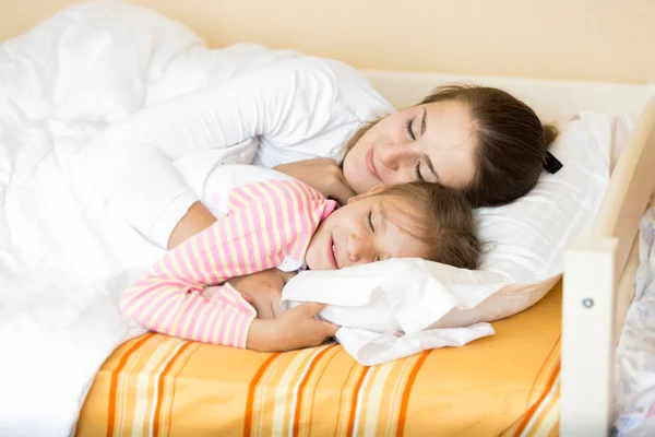 Retrato de niña durmiendo con la madre en la cama — Foto de Stock