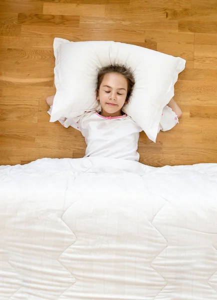 Sorrindo menina deitada no chão de pijama — Fotografia de Stock