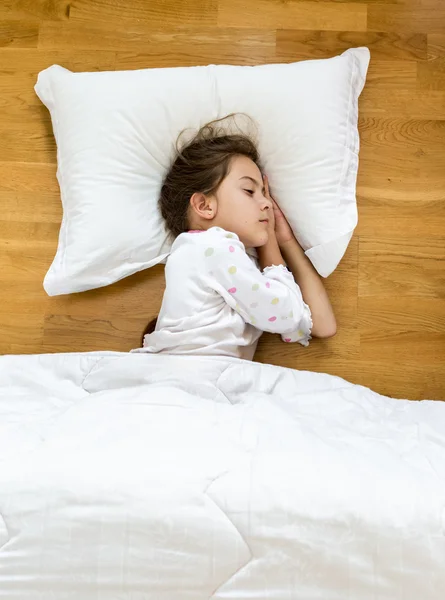 Brunette little girl sleeping on floor covered with blanket — Stock Photo, Image