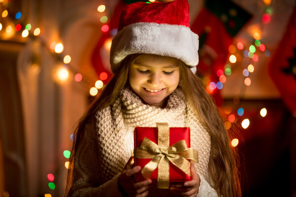 Menina olhando para caixa aberta com presente de Natal — Fotografia de Stock