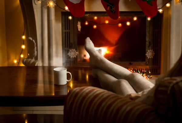 Female legs in woolen stockings warming up at fireplace — Stock Photo, Image