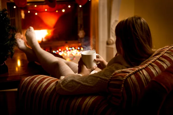 Photo from back of woman warming up fireplace at Christmas — Stock Photo, Image