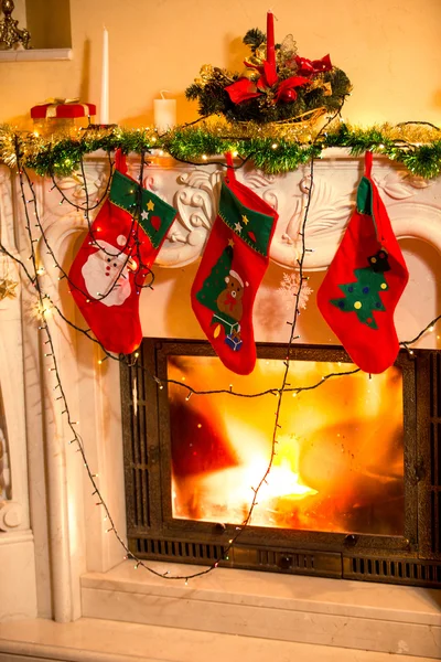 Three Christmas stockings hanging on decorated fireplace — Stock Photo, Image