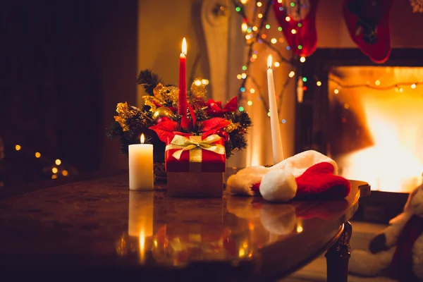 Toned photo of burning candles, fireplace and giftbox at christm — Stock Photo, Image