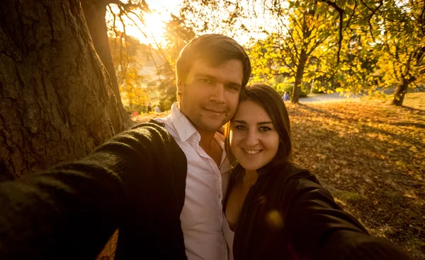 Selfie of romantic couple at autumn park at sunset — Stock Photo, Image