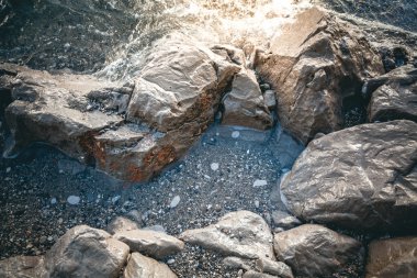 gri taş denizde günbatımında desteklemek