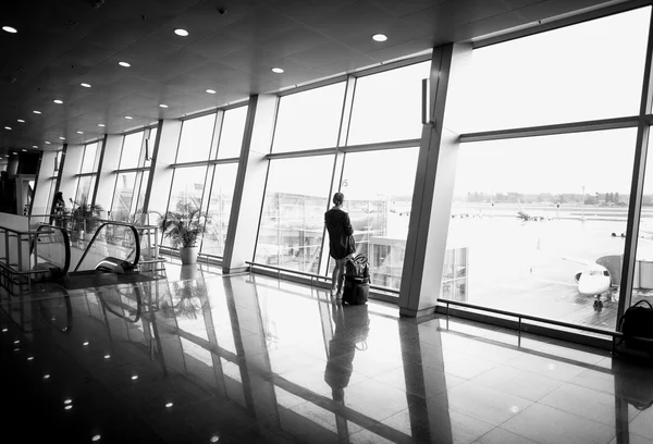 Monochrome  photo of woman standing in front of big window at ai — Stock Photo, Image