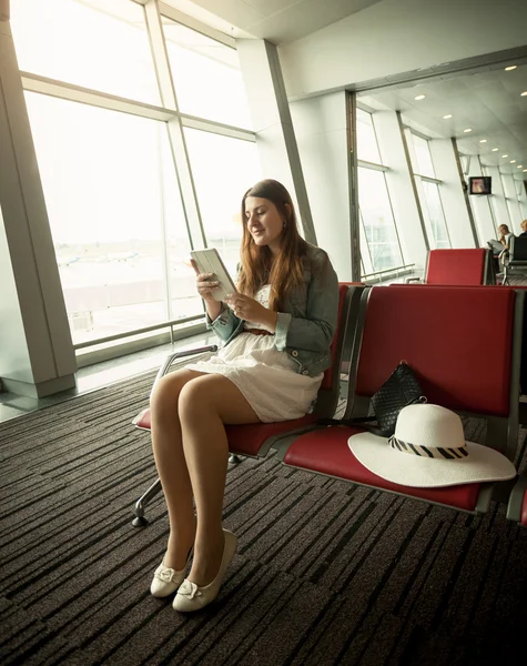Mulher usando tablet digital enquanto espera pela partida do avião — Fotografia de Stock